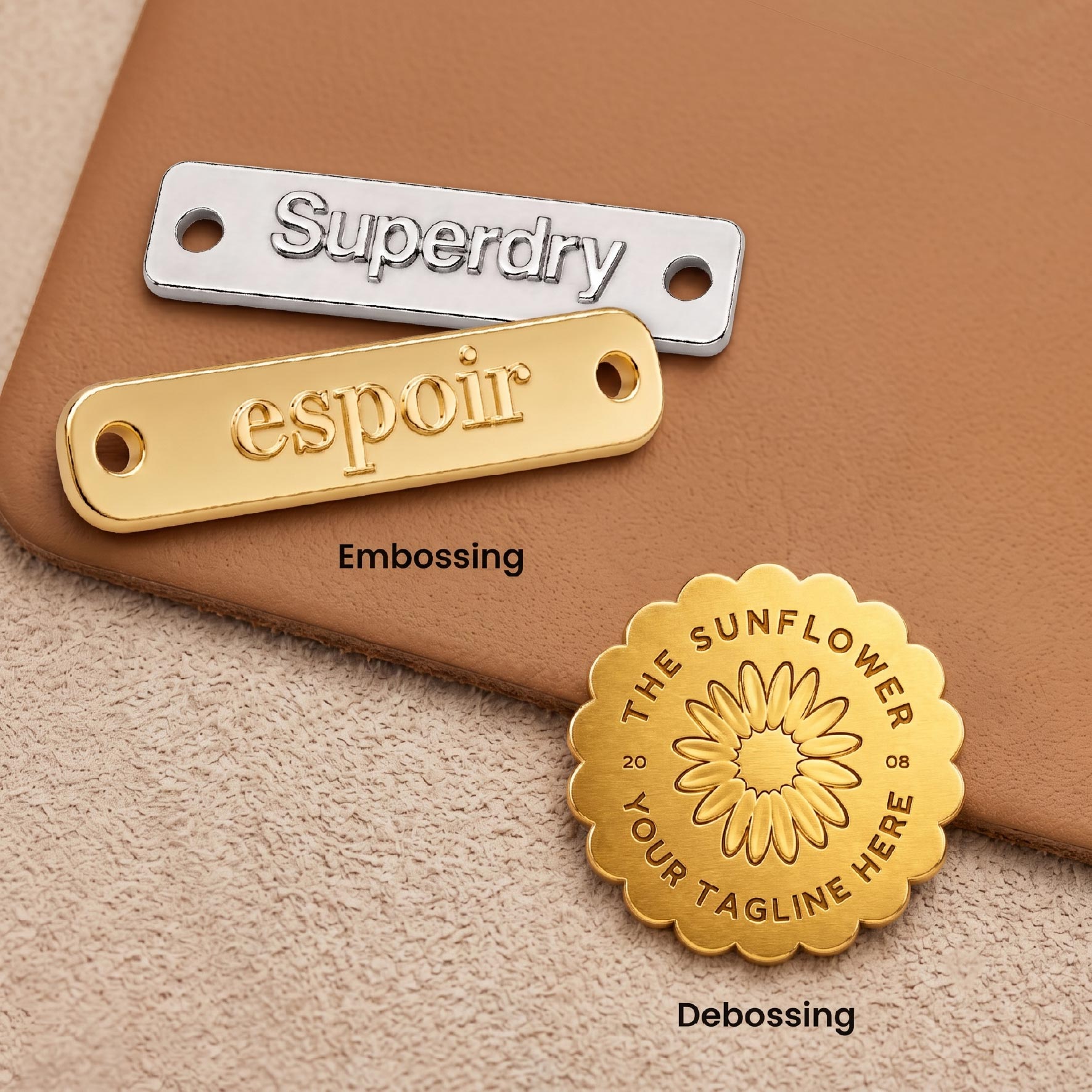 Embossed and debossed metal tags highlighting raised and recessed logo textures