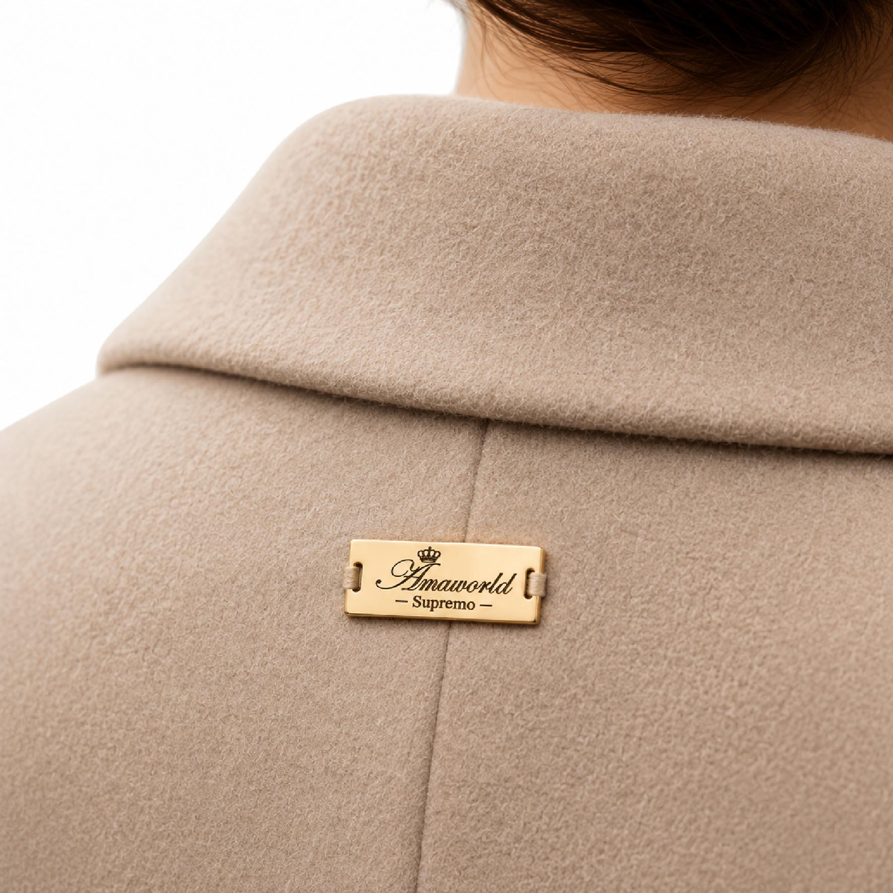 Sew-on metal label elegantly stitched onto a premium wool coat for high-end clothing