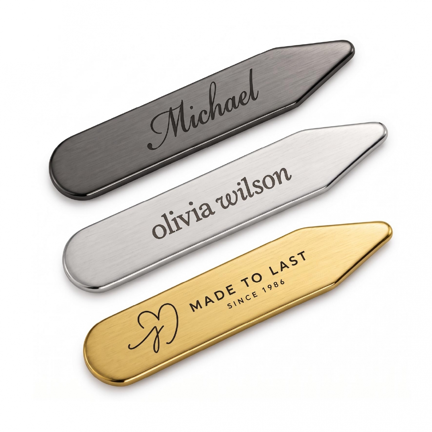 Gunmetal, silver, and gold metal collar stays displaying different engraved names and logo designs