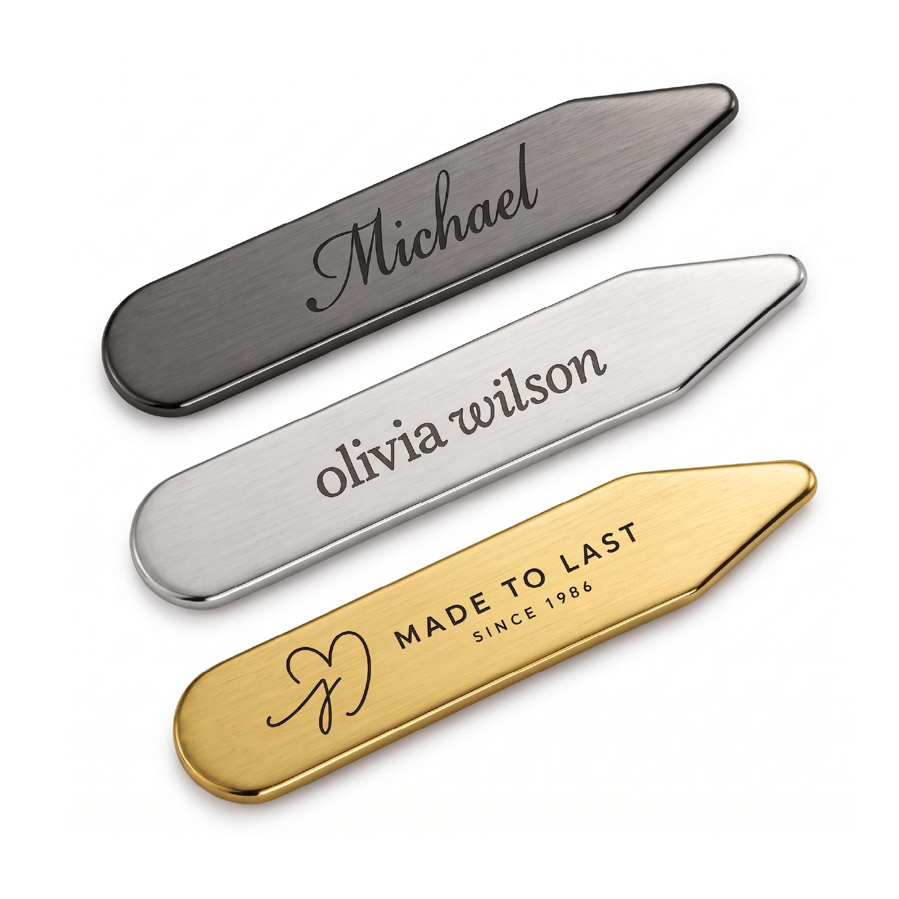 Gunmetal, silver, and gold metal collar stays displaying different engraved names and logo designs