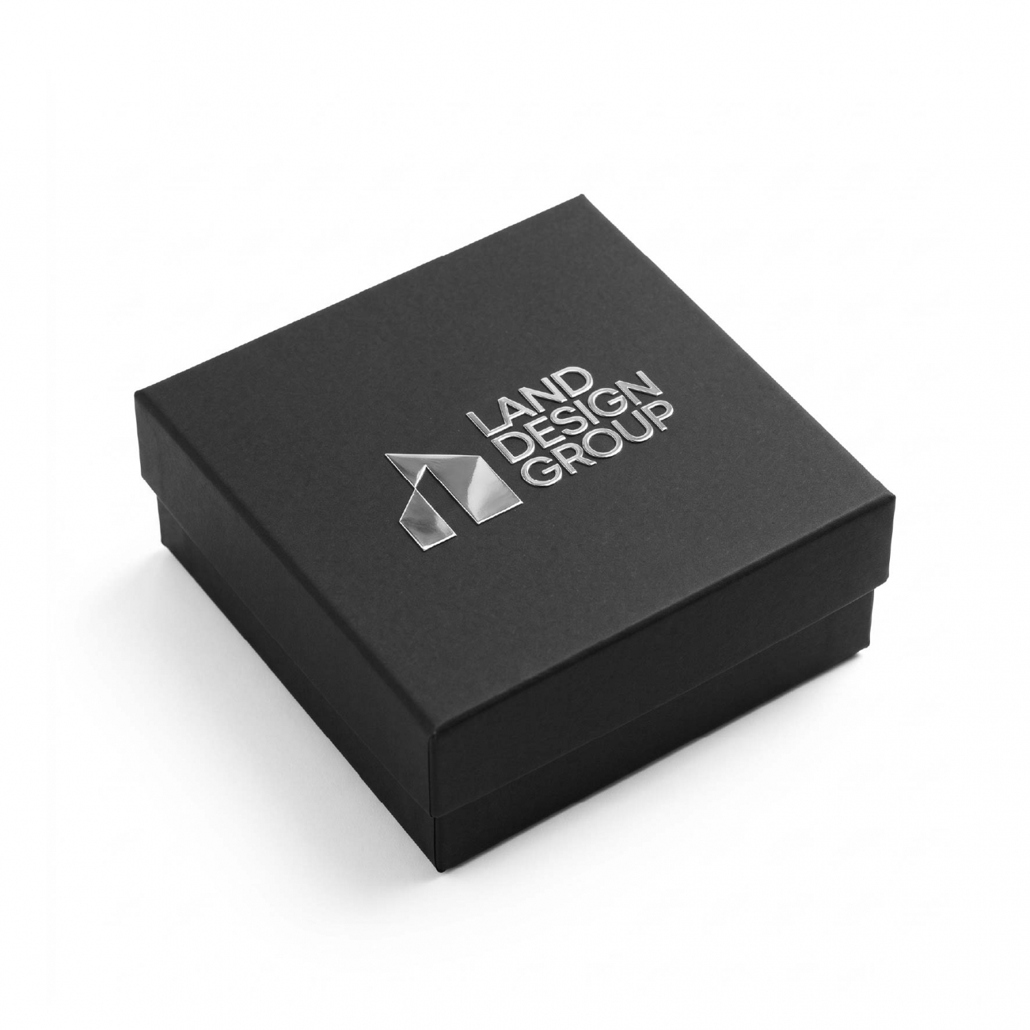 Silver metal logo applied to a black presentation box for premium packaging branding