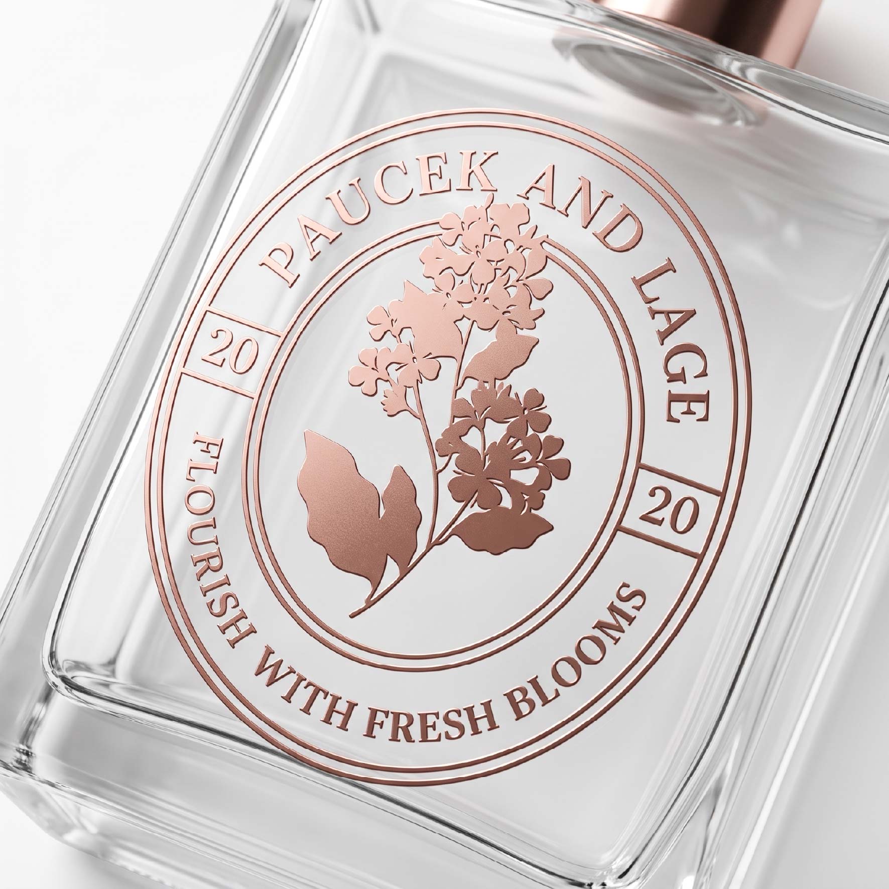 Rose gold floral metal label showing fine lines and curved lettering on a clear container