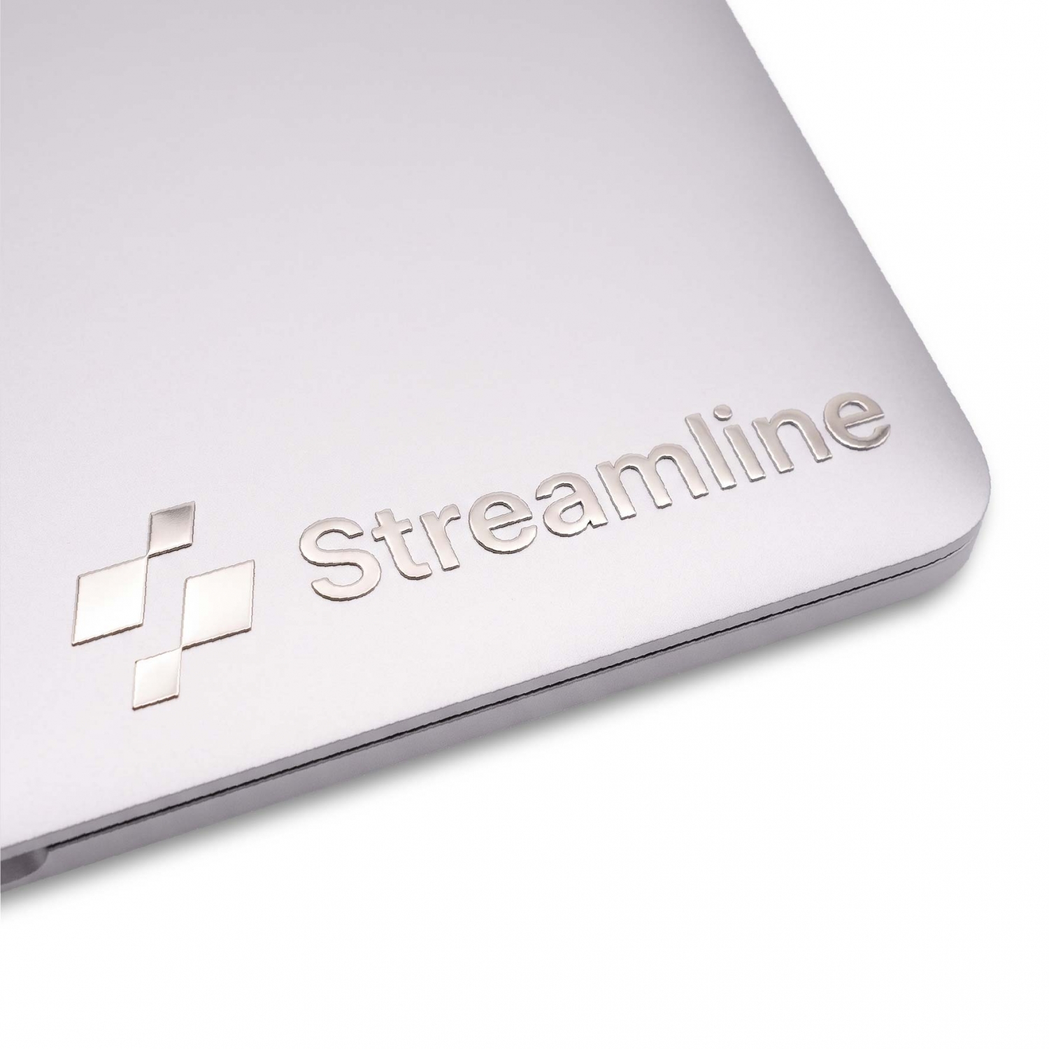 Silver metal logo sticker applied to a laptop surface